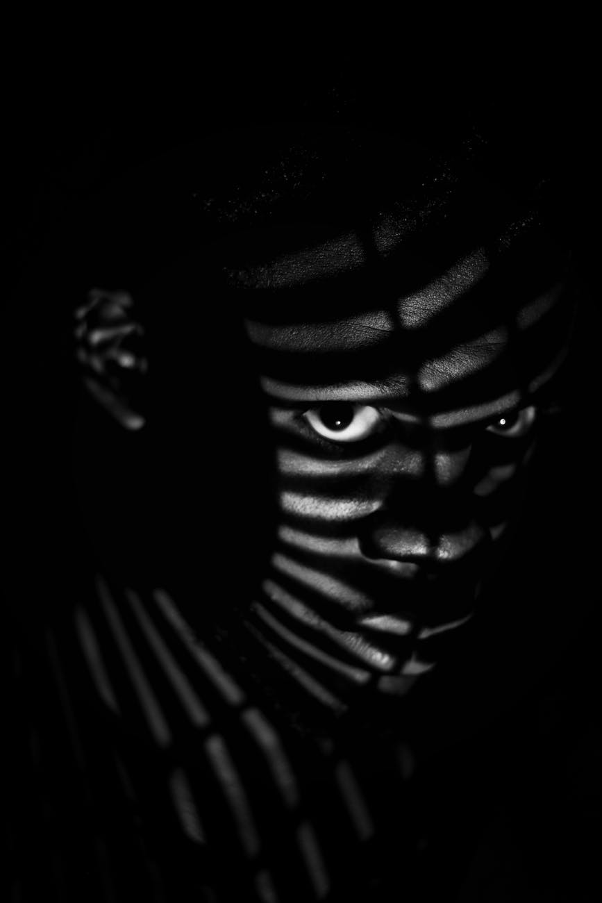 man in shadow with slats of light on his face