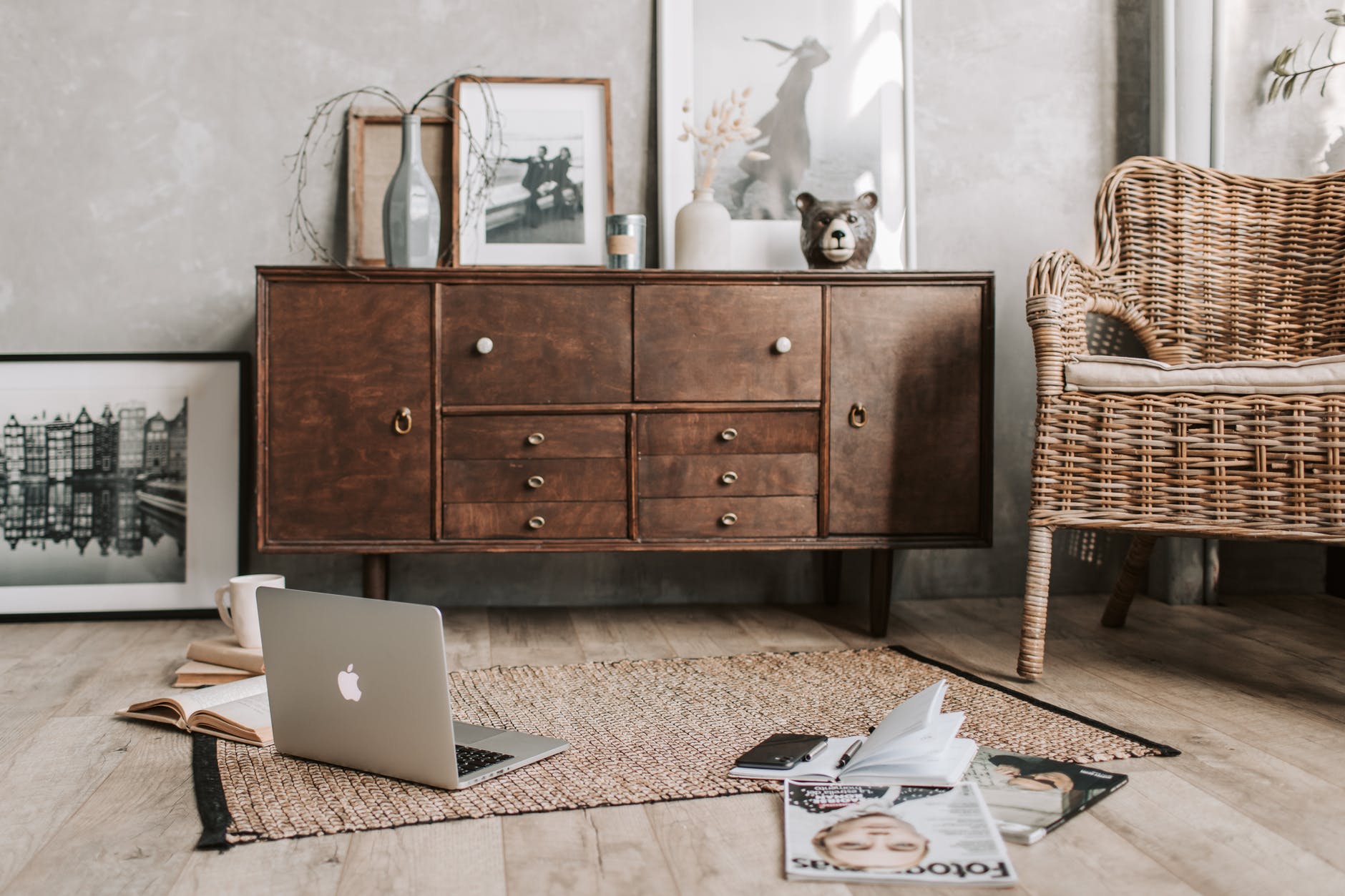 open laptop on plank floor with chair and cabinet in background of neutral colors